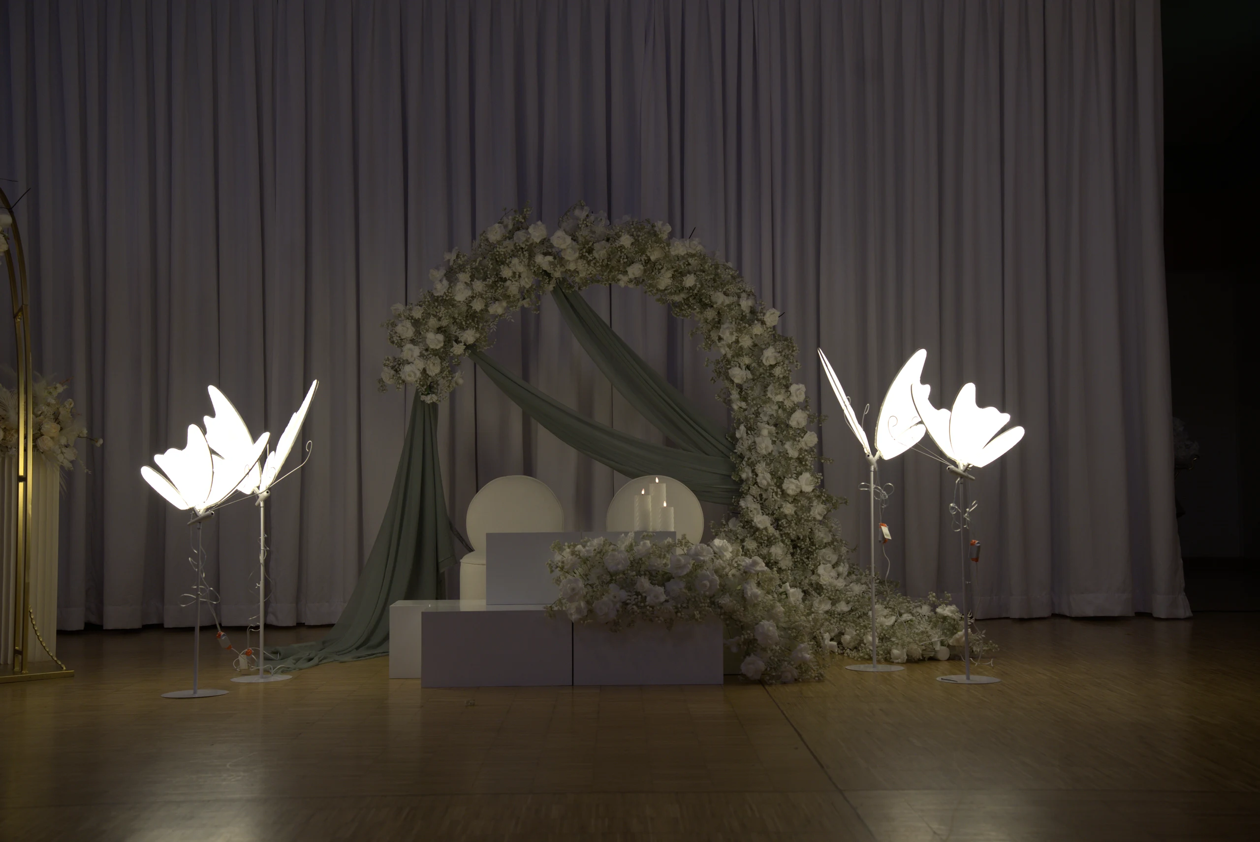 Echtes Bühnendesign mit Kerzen und floralen Bögen